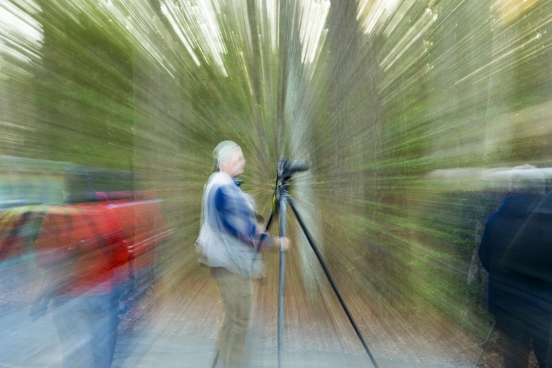 Pulling a fully extended telephoto lens back at a slow shutter speed 